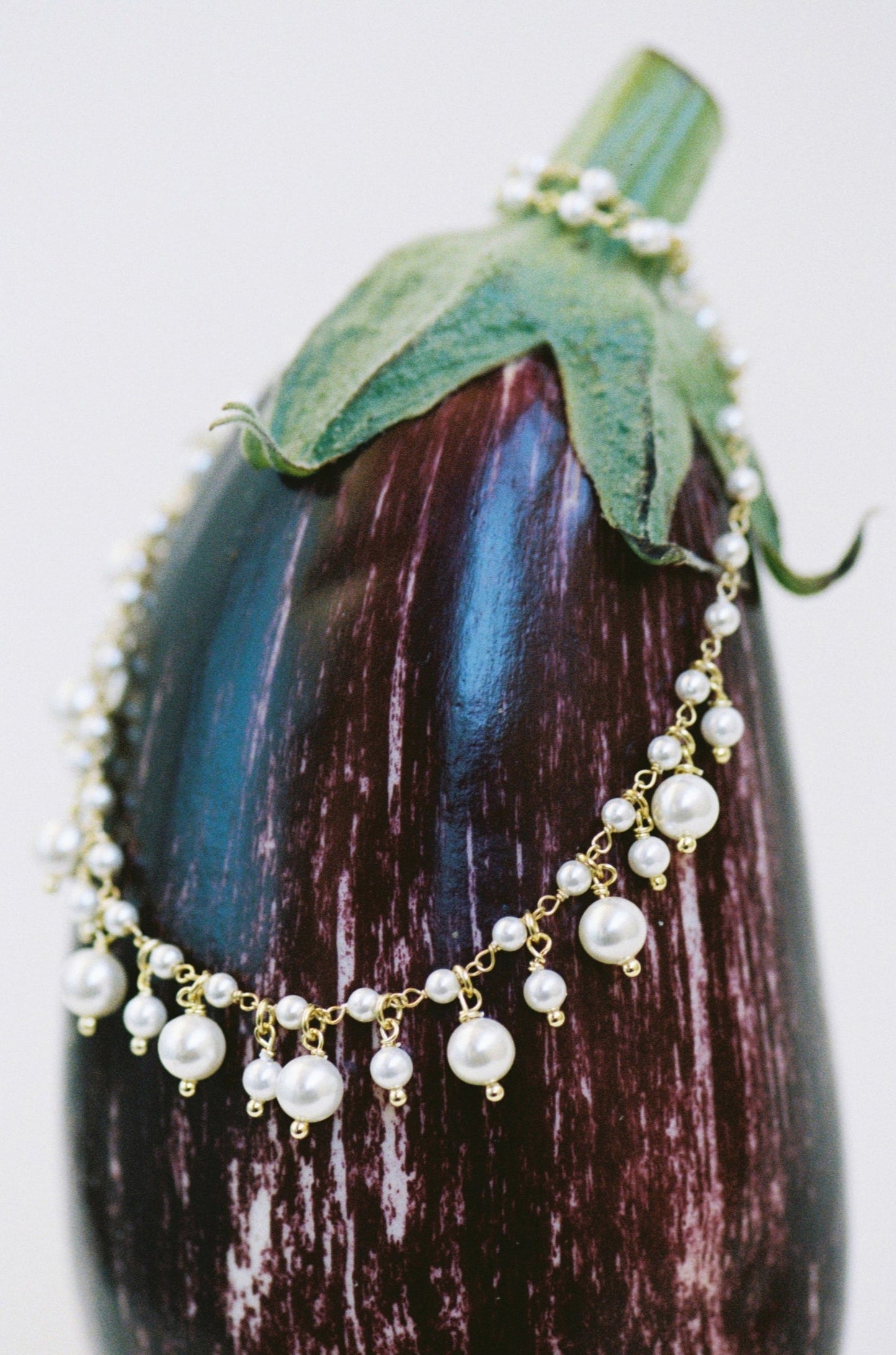 Collar giardino di perle sobre berenjena
