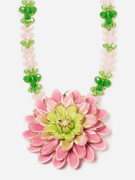 Collar con cuentas verdes y rosas pastel, con un gran colgante de flor tipo dalia esmaltada en tonos rosados y verde lima, sobre fondo blanco. Cashfana.