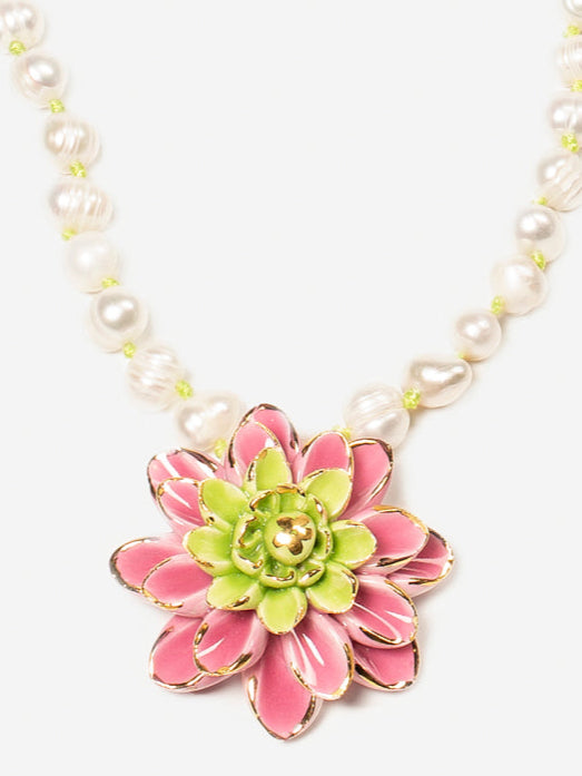 Colgante central de flor esmaltada en rosa y verde lima, sobre fondo blanco. Cashfana.