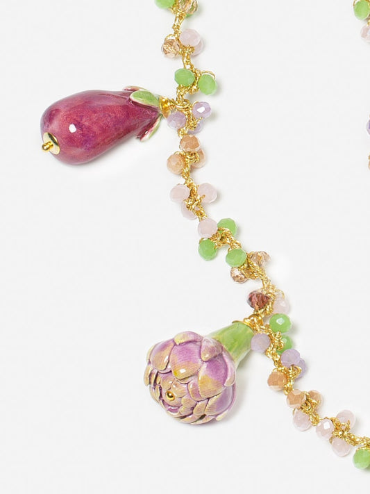 charms colgantes de cerámica: berenjena morada, alcachofa verde y morada sobre fondo blanco. Cashfana.