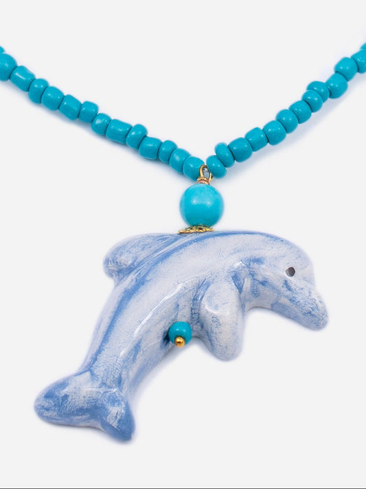 detalle de collar delfin sobre fondo blanco cashfana
