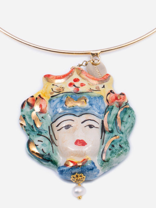 Collar rígido dorado con colgante de busto femenino siciliano en cerámica pintada a mano con detalles florales y perla decorativa.