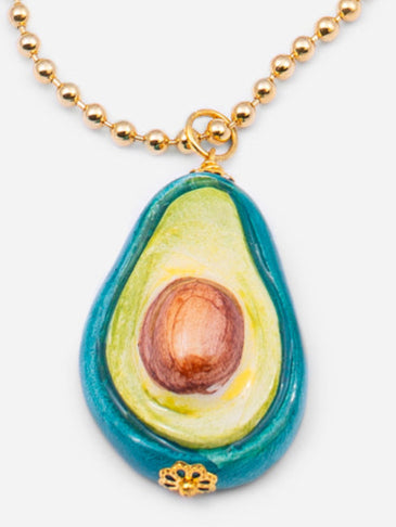 Collar de cuentas doradas con colgante de cerámica en forma de aguacate, sobre fondo blanco. Cashfana.
