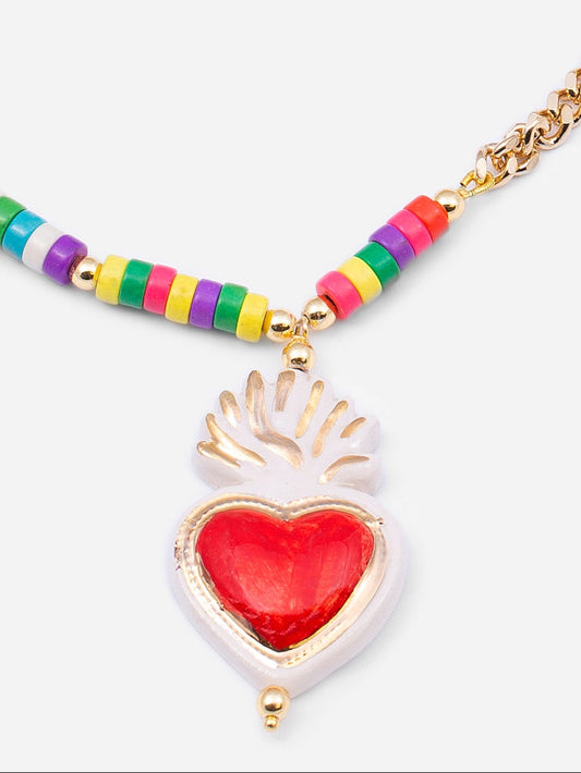 Colgante de cerámica en forma de corazón rojo coronado por llama, sobre fondo blanco.
Cashfana.