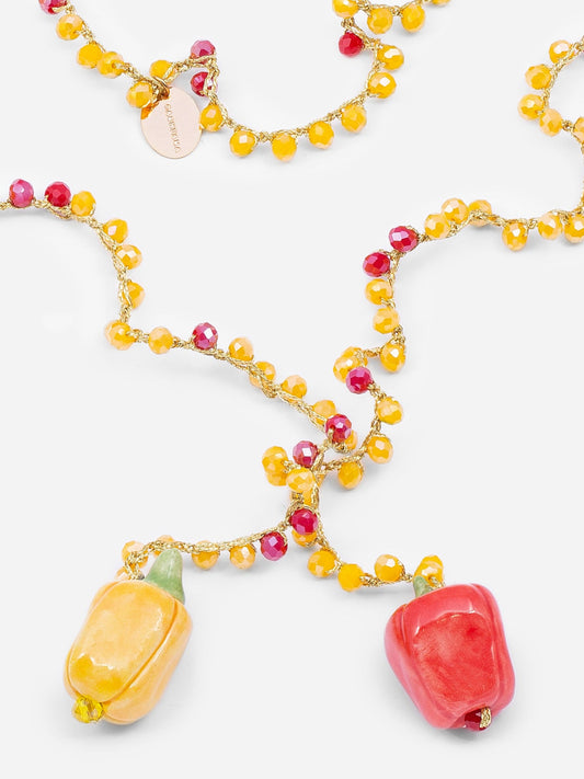 Pimientos de cerámica en rojo y amarillo, del collar largo de hilo trenzado con cuentas rojas y amarillas.