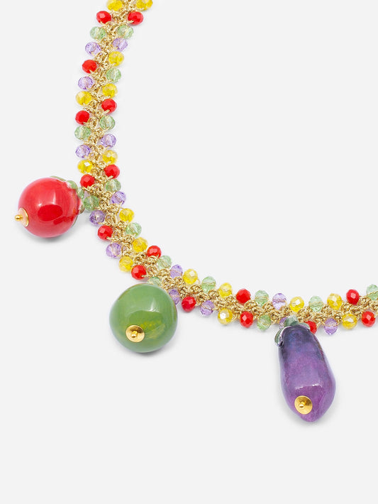 Collar de cuentas multicolor con cinco charms colgantes de cerámica: tomate rojo, manzana verde, berenjena morada, sobre fondo blanco.