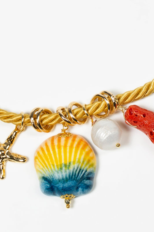 Detalle de concha amarilla y azul sobre fondo blanco. Cashfana.