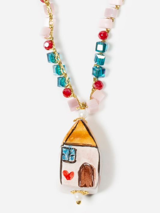 Colgante de cerámica pintado a mano en forma de casa, sobre fondo blanco. Cashfana.