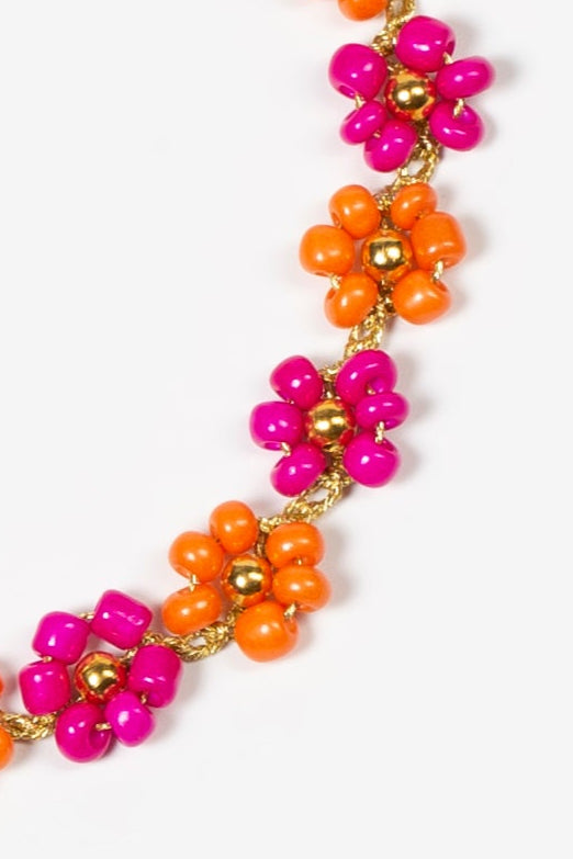 Choker Nardo de flores hechas a mano con cuentas fucsia brillante y naranja mandarina, con detalles dorados, sobre fondo blanco. Cashfana.