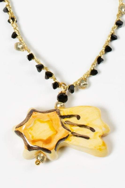 detalle de collar estrella fugaz sobre fondo blanco