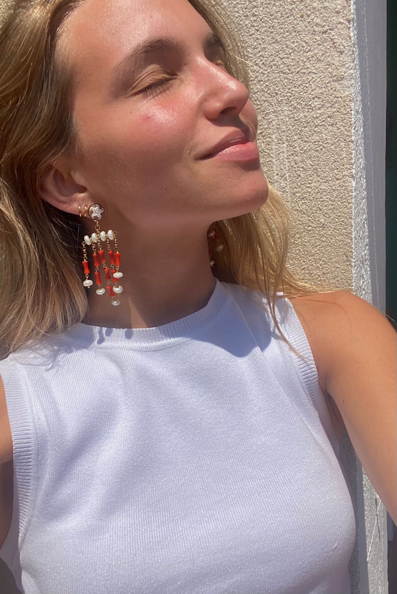 Pendientes largos con camafeo de estrella, coral natural y perlas. Sofisticación con esencia marina.
Con camiseta blanca.