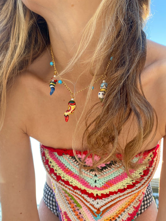 Collar corto de cadena dorada con cuentas turquesa y colgantes de pimientos esmaltados en distintos colores combinado con bandana cashfana.