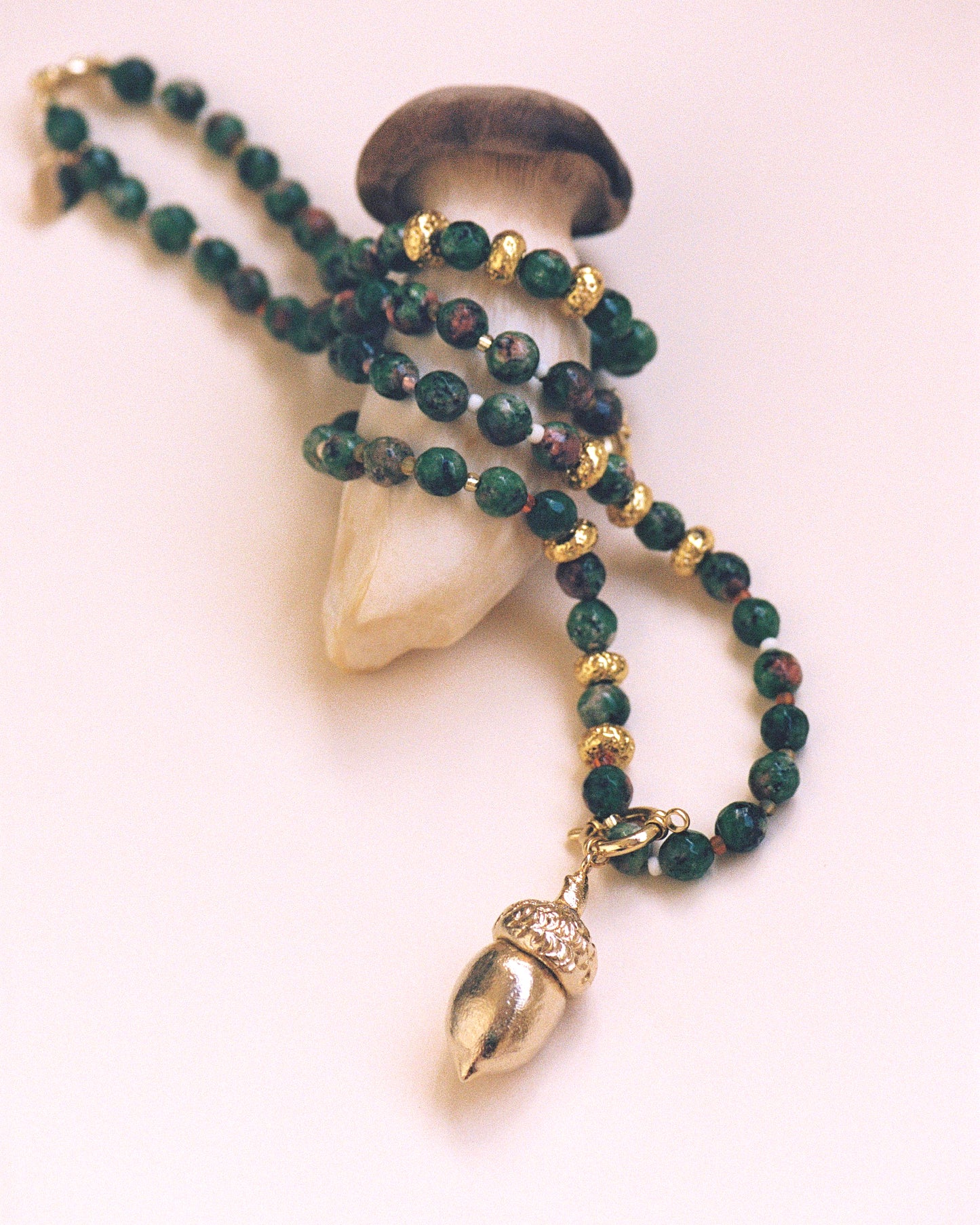 GOLDEN ACORN NECKLACE, LONG WITH DARK GREEN BEADS AND A BRONZE ACORN-SHAPED PIECE