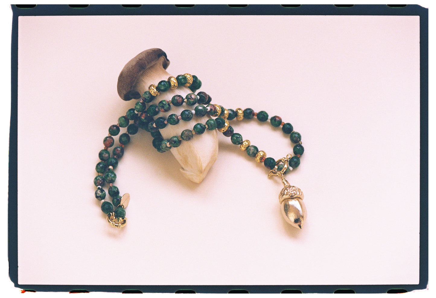GOLDEN ACORN NECKLACE, LONG WITH DARK GREEN BEADS AND A BRONZE ACORN-SHAPED PIECE