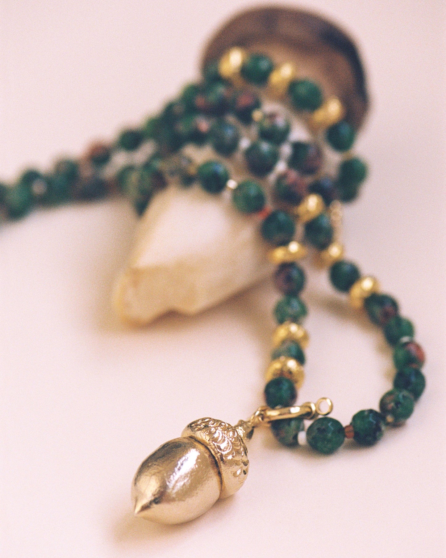 GOLDEN ACORN NECKLACE, LONG WITH DARK GREEN BEADS AND A BRONZE ACORN-SHAPED PIECE