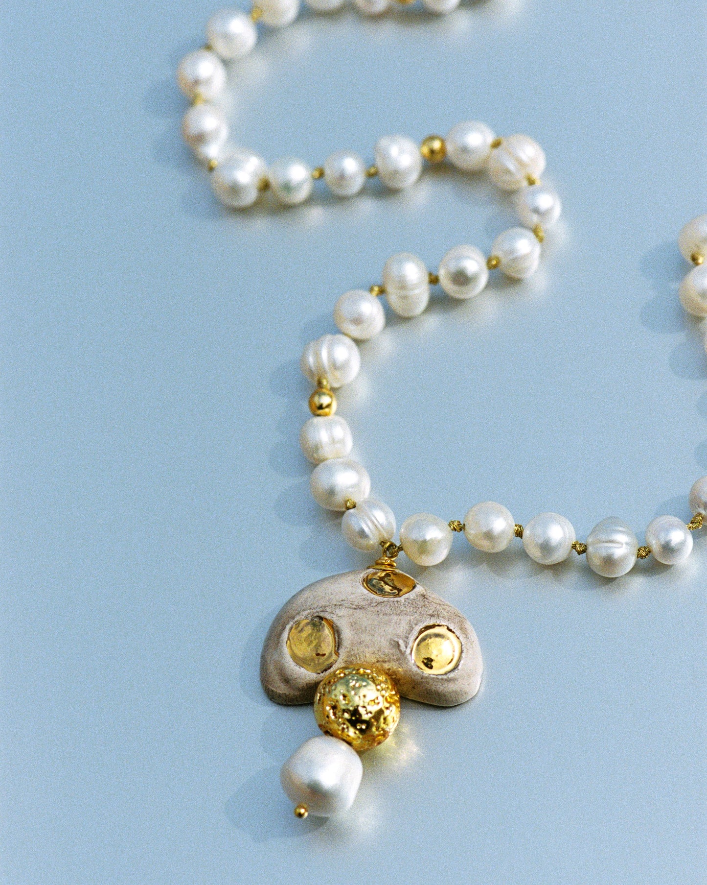 CHAMPI TOPO, LONG PEARL NECKLACE WITH BROWN MUSHROOM PENDANT.
