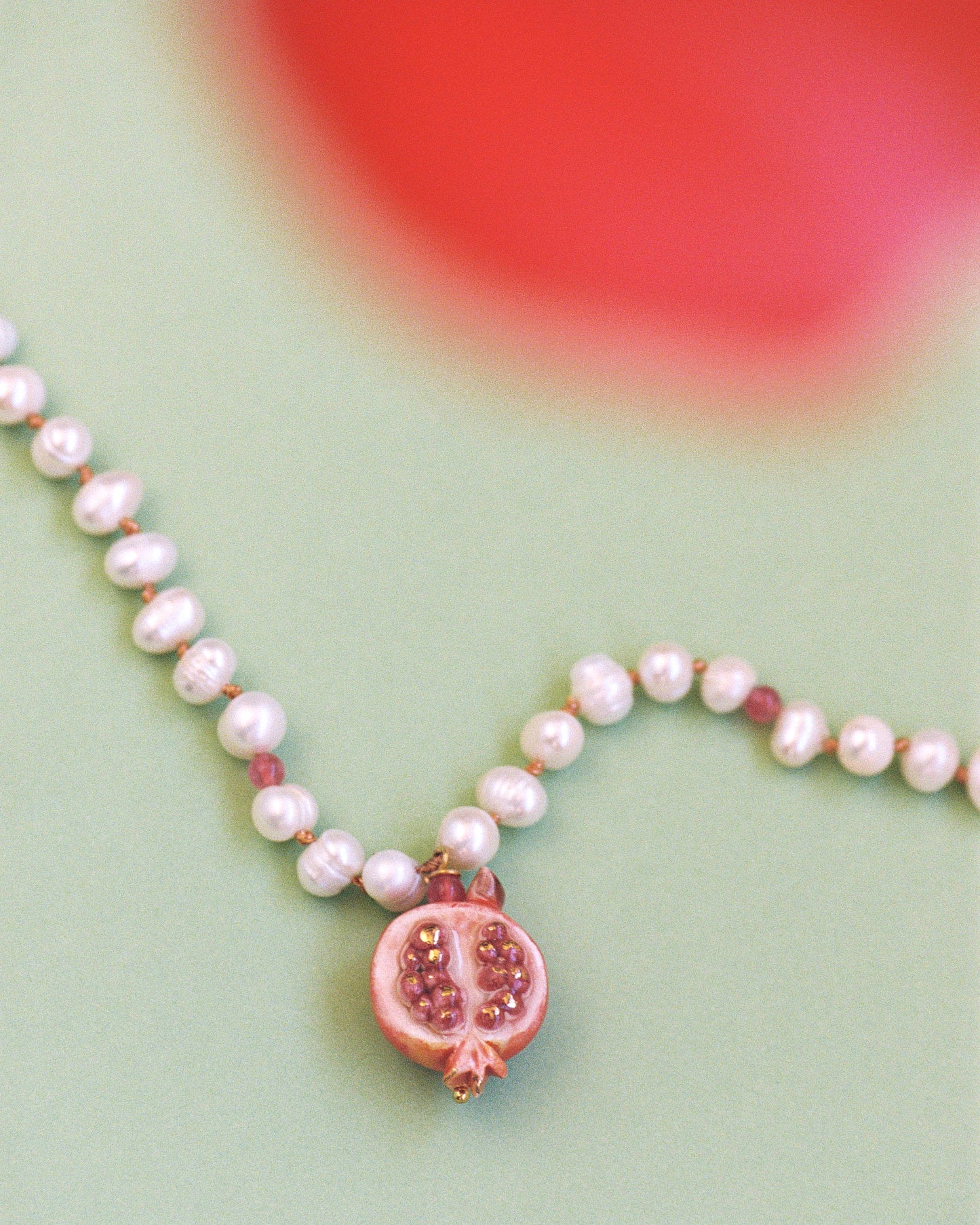 MEDIA GRANADA, SHORT PEARL NECKLACE WITH A PIECE OF CERAMIC IN THE SHAPE OF A HALF POMEGRANATE