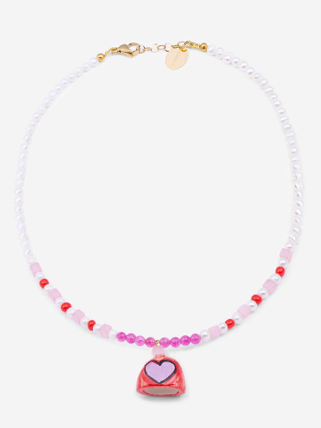 Collar corto de cuentas blancas, rosas y rojas con colgante de cerámica en forma de campana roja decorada con corazón rosa, sobre fondo blanco. Cashfana.